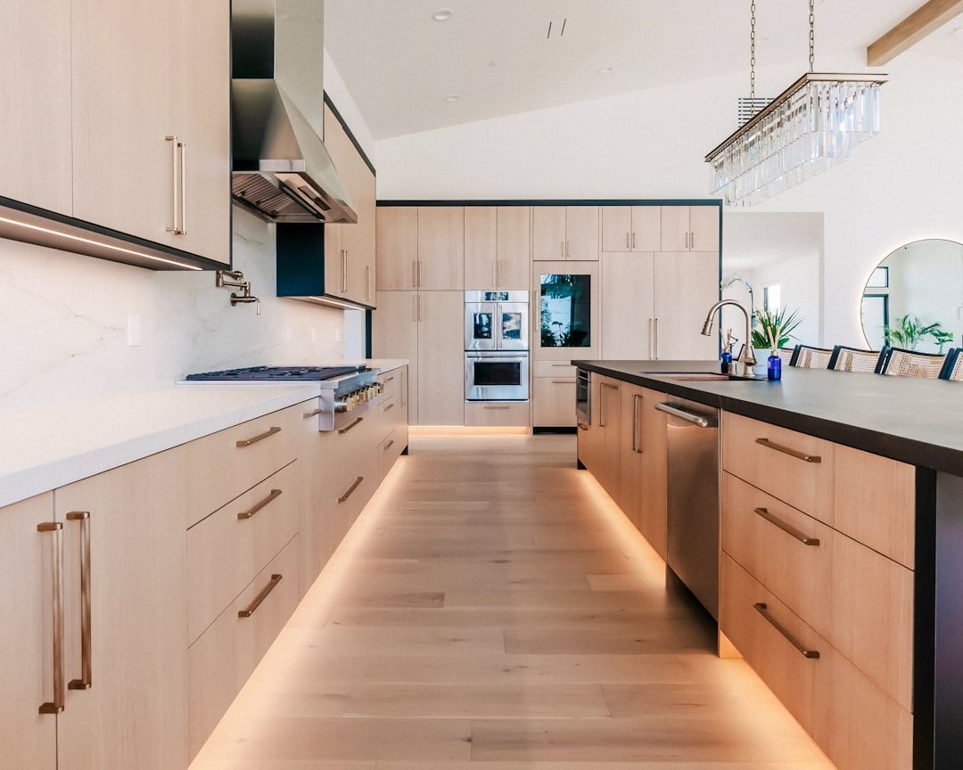 Moderne keuken met lichte houten kasten en lange metalen handgrepen.