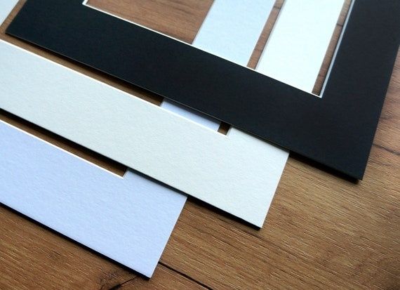 Zwarte en witte passe-partouts in verschillende breedtes op een houten tafel