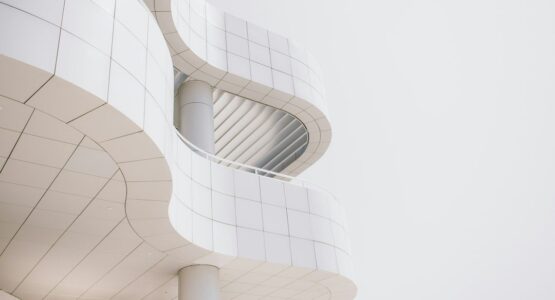 Minimalistische witte gevel met gebogen lijnen en een ronde zuil